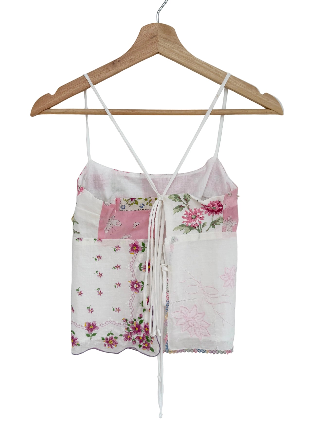 Floral print top on a wooden hanger against a white background