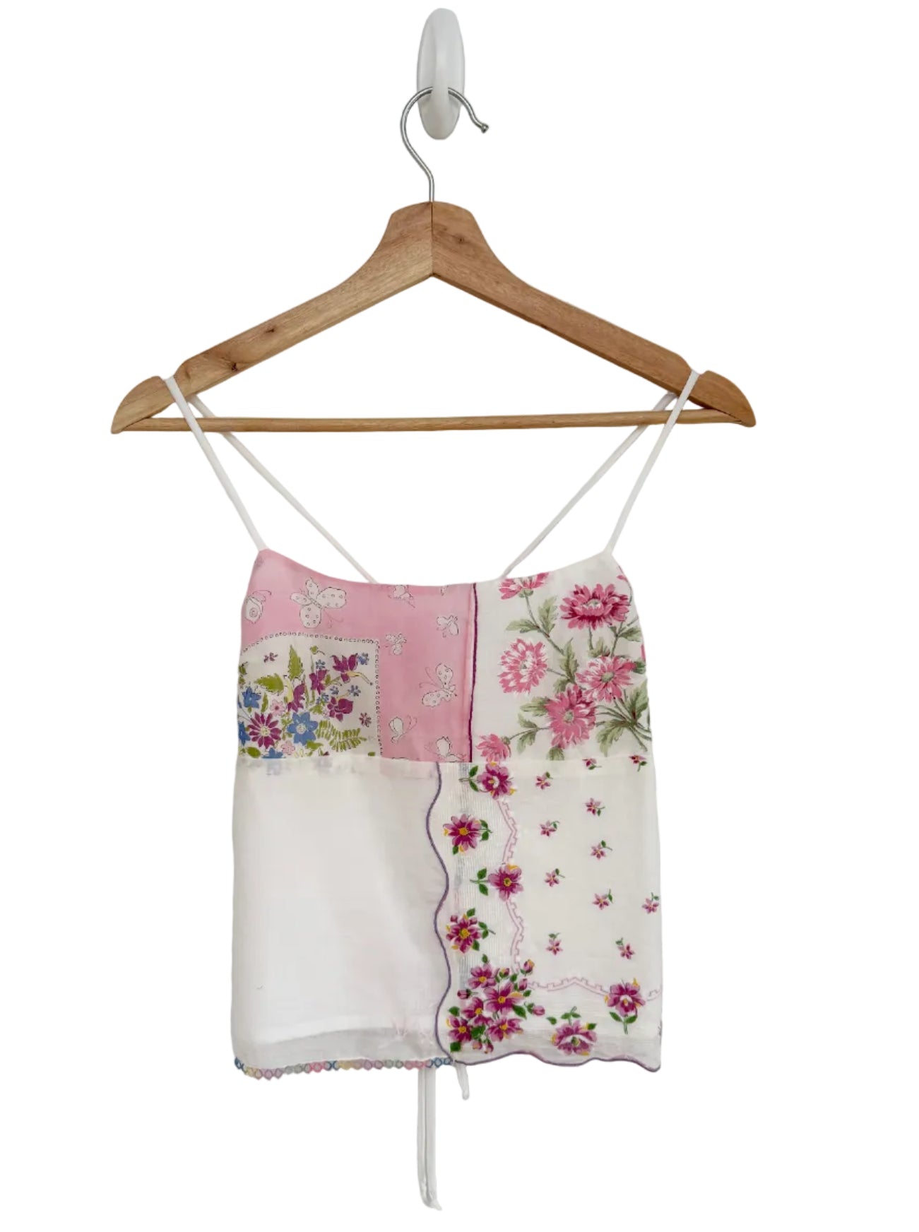 Floral halter top on a wooden hanger against a plain background