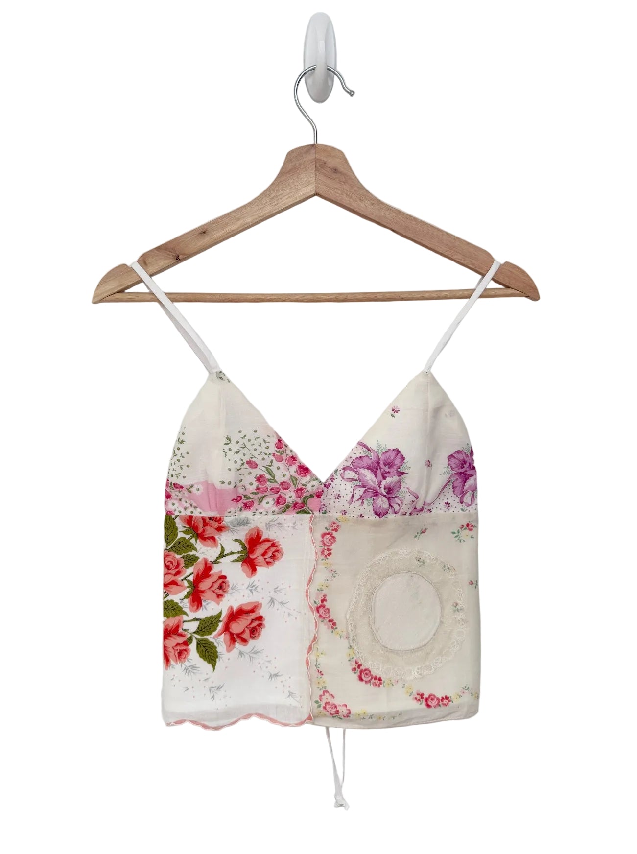Floral-patterned top on a wooden hanger against a white background