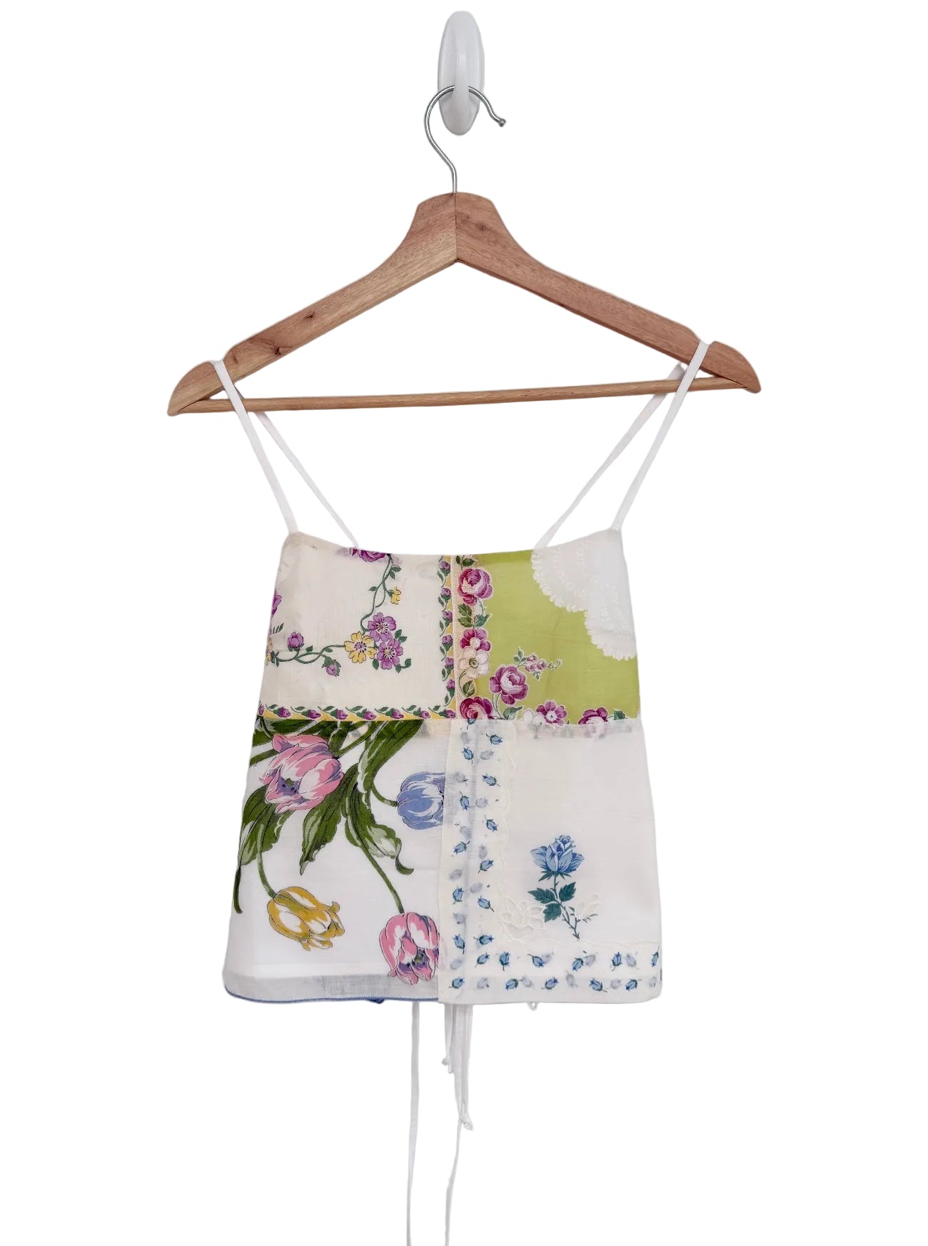 Floral-patterned top on a wooden hanger against a white background