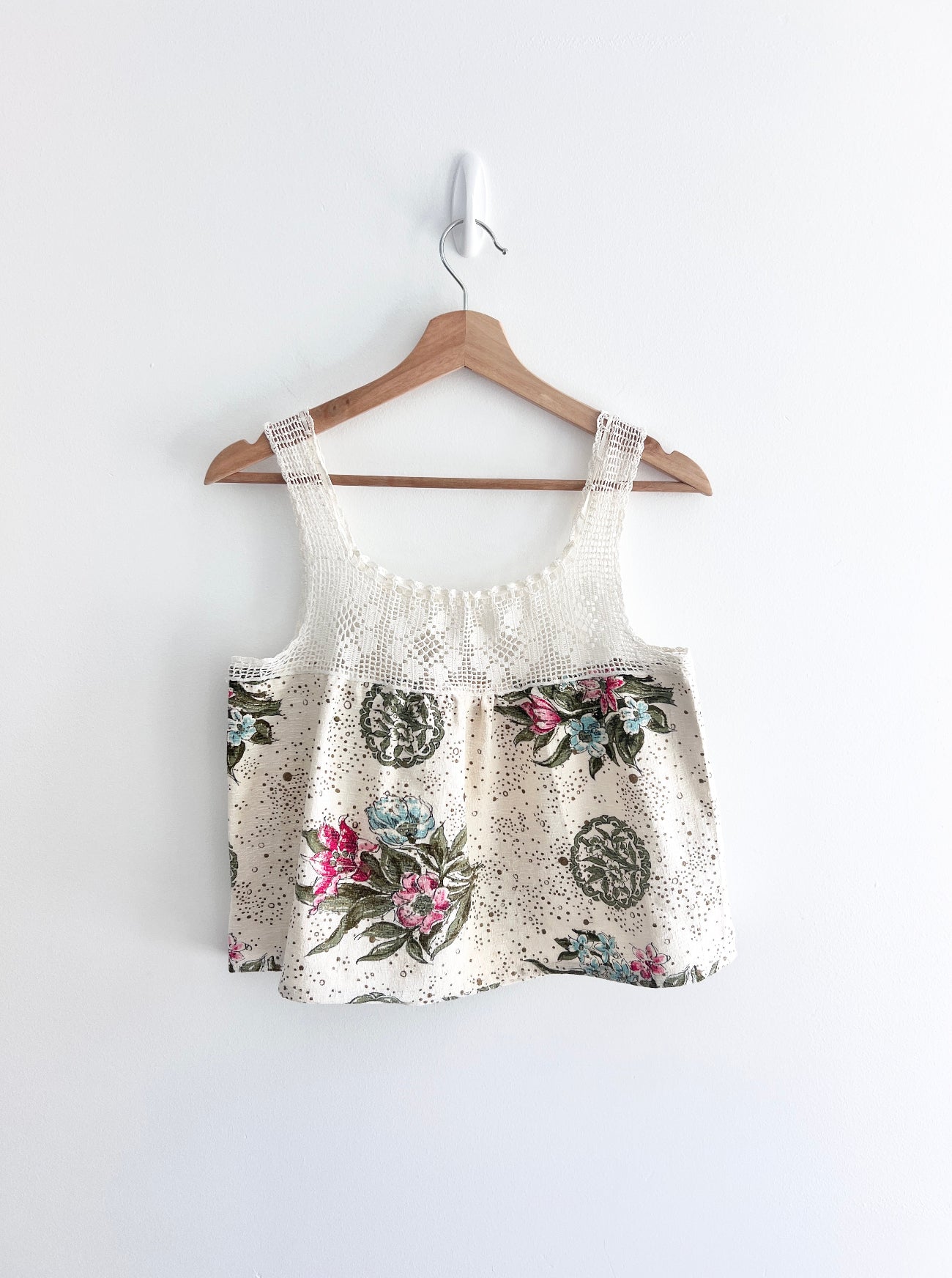 Floral-patterned top and shorts set on a hanger against a white background