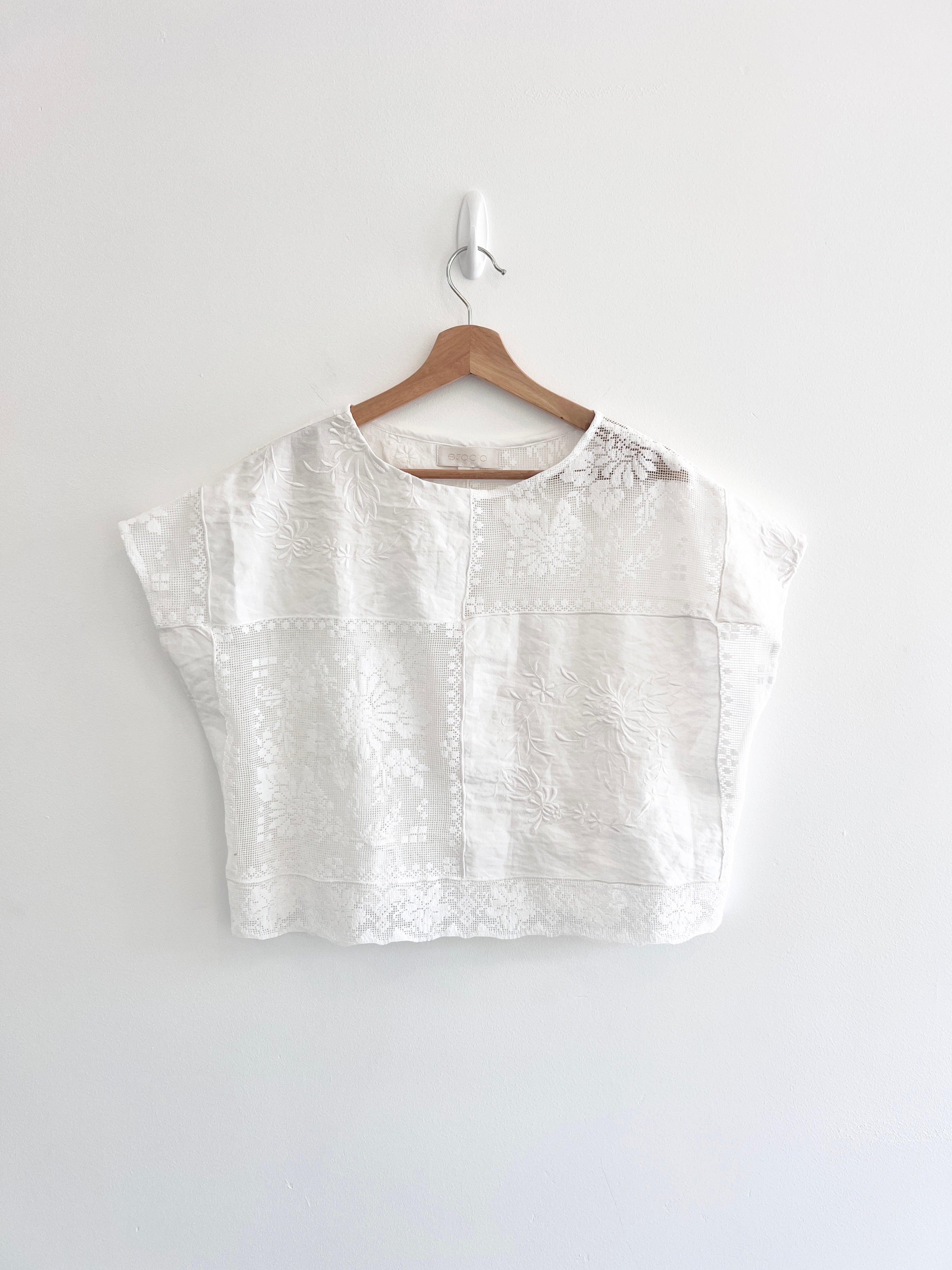 White blouse on a wooden hanger against a white background