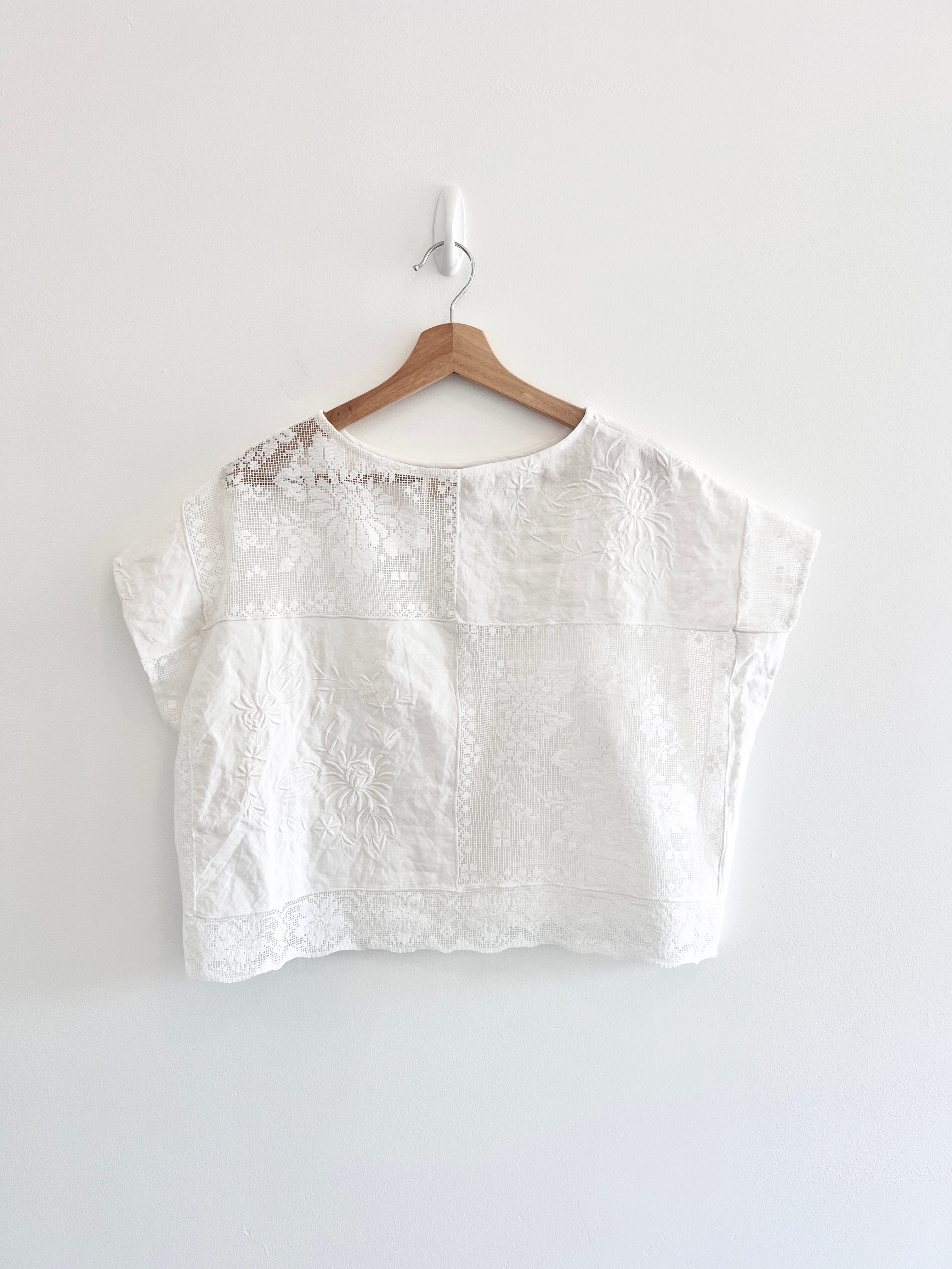 White blouse on a wooden hanger against a white background