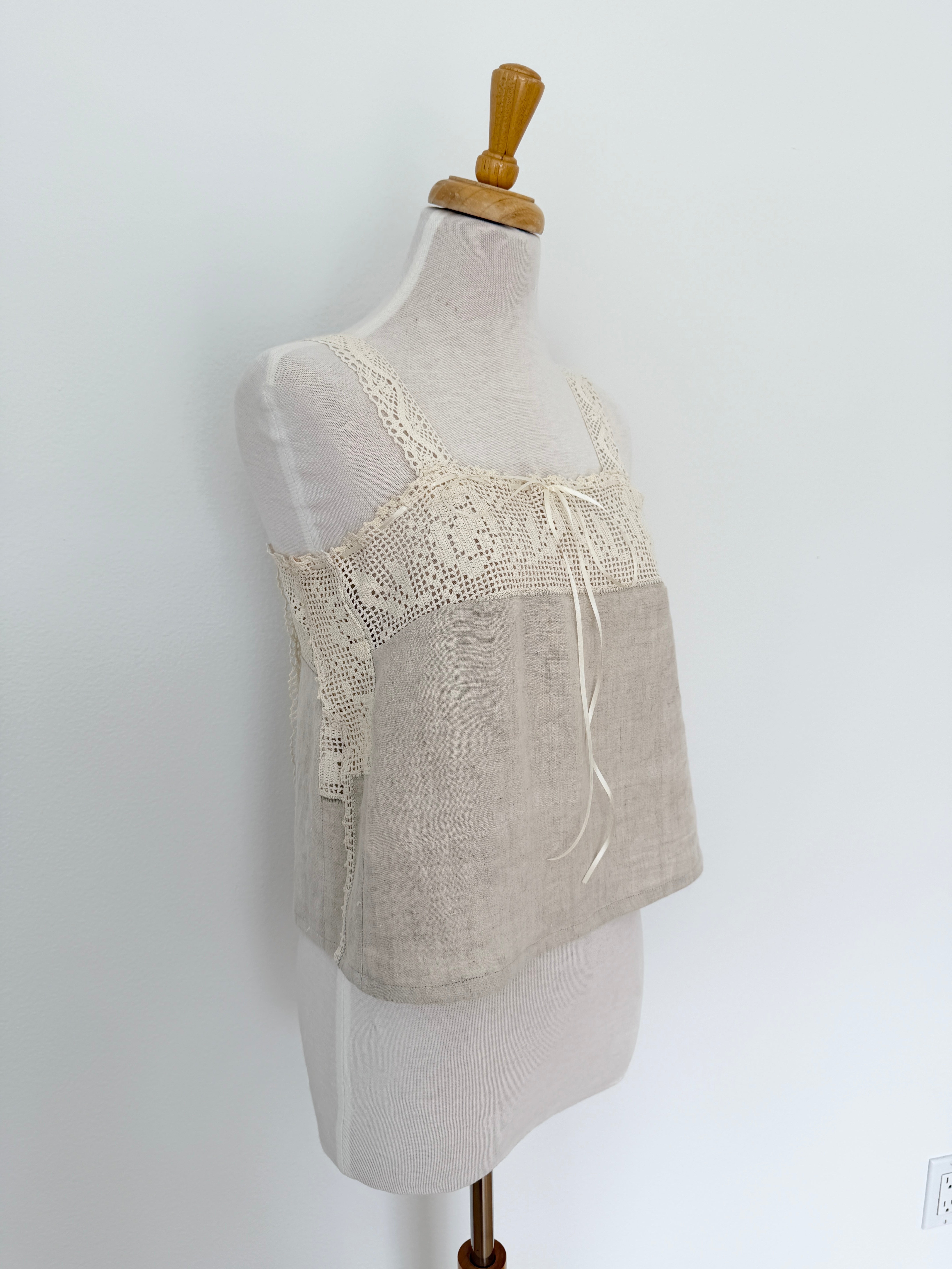 Lace-trimmed beige top on a mannequin against a white background
