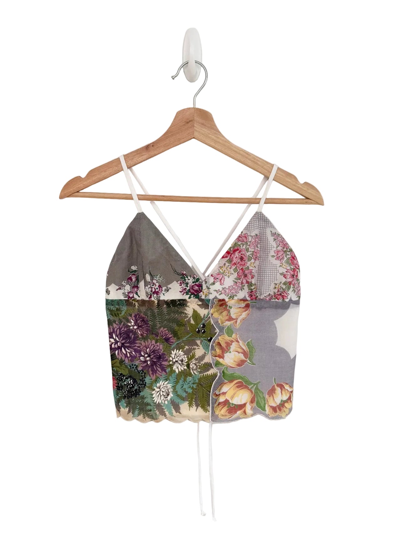 Floral-patterned top on a wooden hanger against a white background