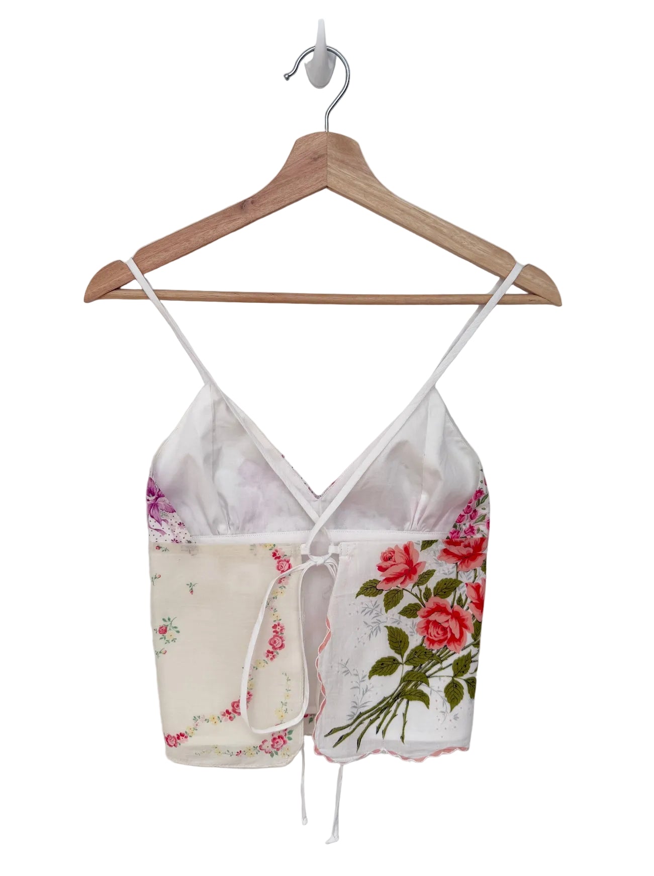 Floral print top on a wooden hanger against a white background