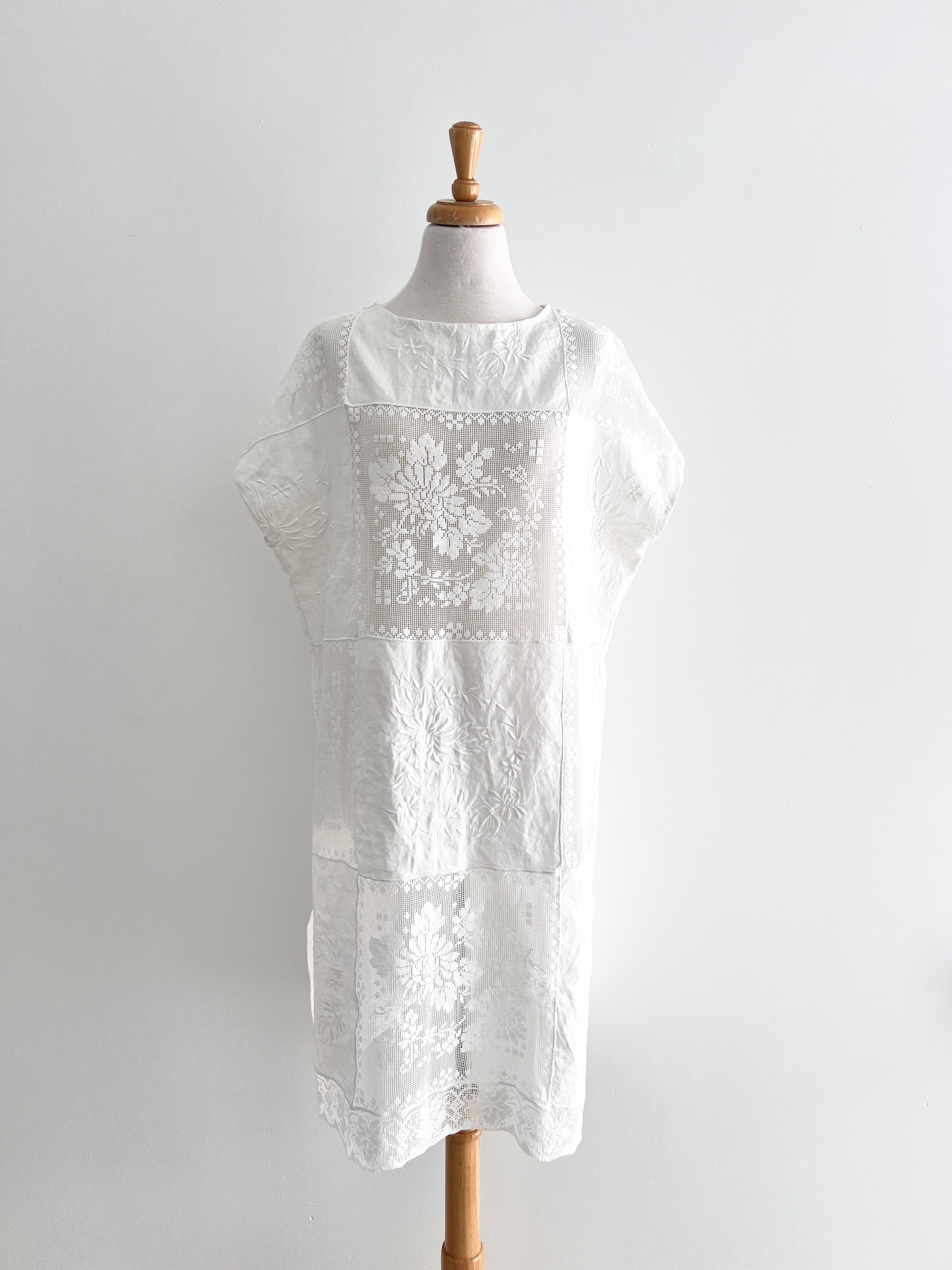 White embroidered dress on a mannequin against a plain background