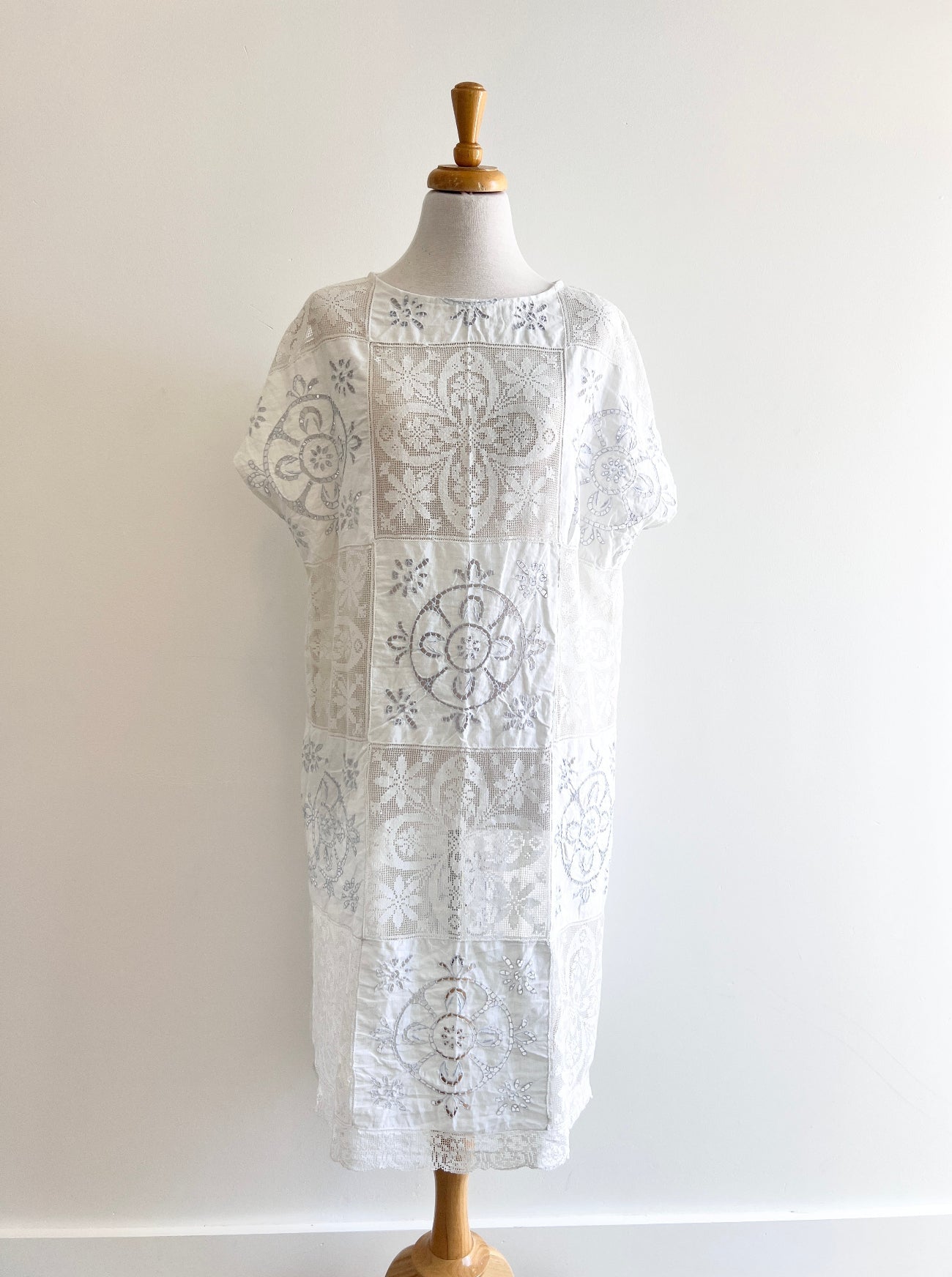 White lace dress on a mannequin against a white background