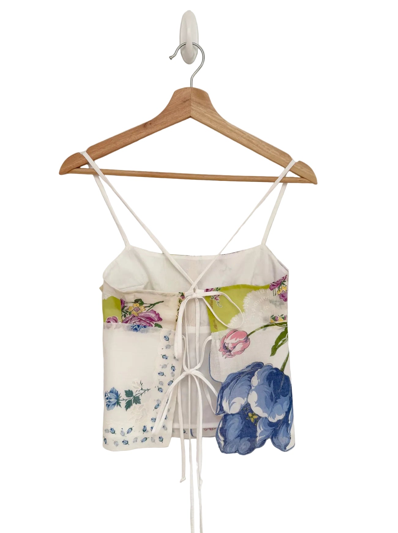 Floral top on a wooden hanger against a plain background